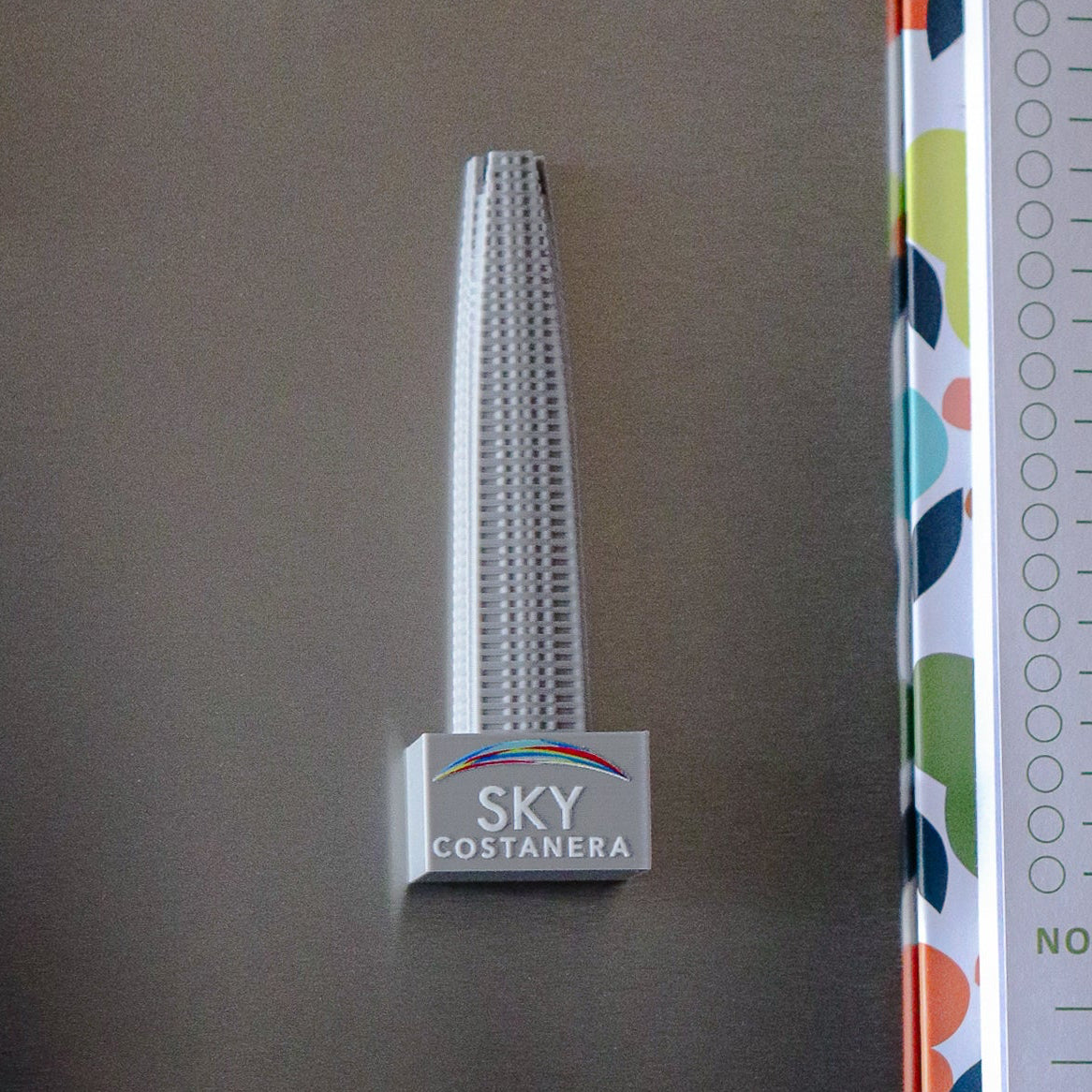 Imán promocional Sky Costanera con diseño tridimensional de la torre, fabricado en impresión 3D
