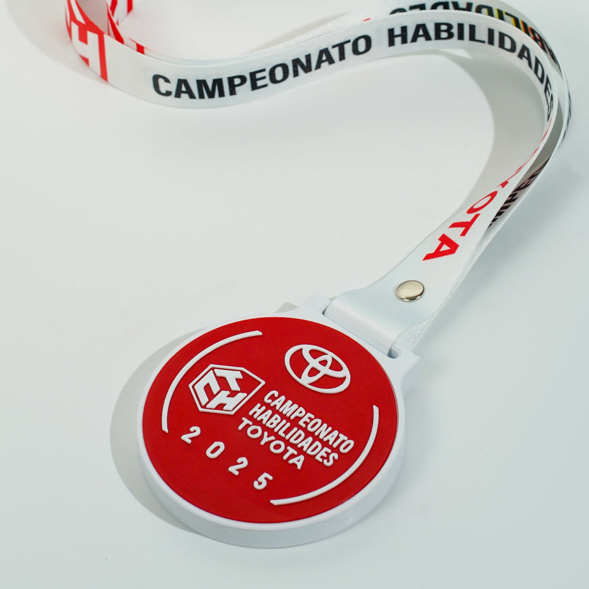 Medalla de premiación personalizada Toyota con lanyard impreso y pieza circular fabricada en impresión 3D, utilizada en el Campeonato de Habilidades Toyota 2025