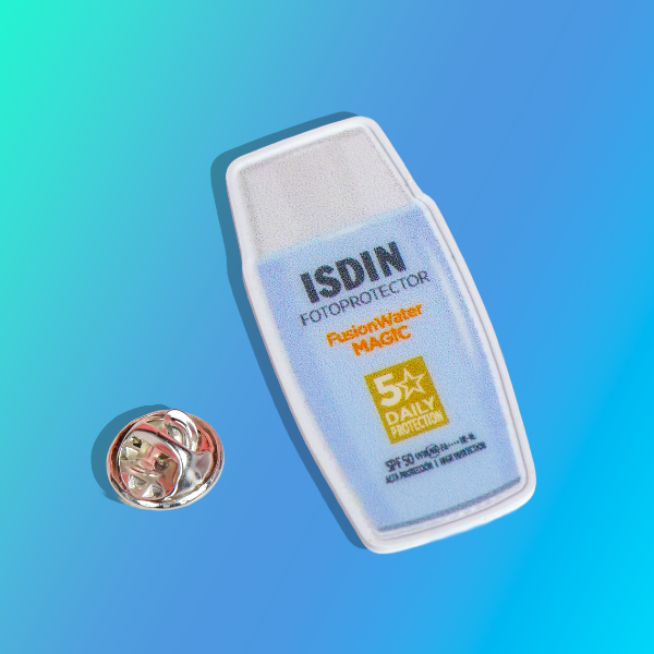 Pin publicitario personalizado de ISDIN, fabricado en impresión 3D, con relieves definidos, alta fidelidad de color y acabado premium.