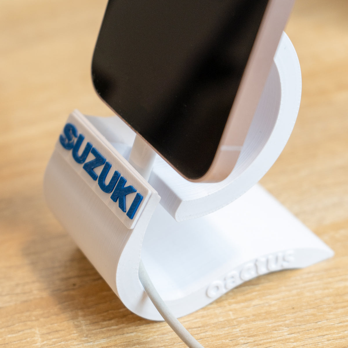 Porta celular de escritorio con diseño personalizado y logo corporativo Suzuki en el frontal